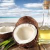 Coconut and Oil bottle on table. Beach in the background